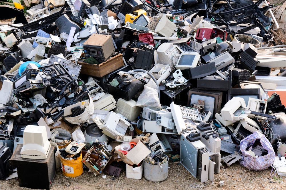 Large pile of electronic waste at outdoor dump